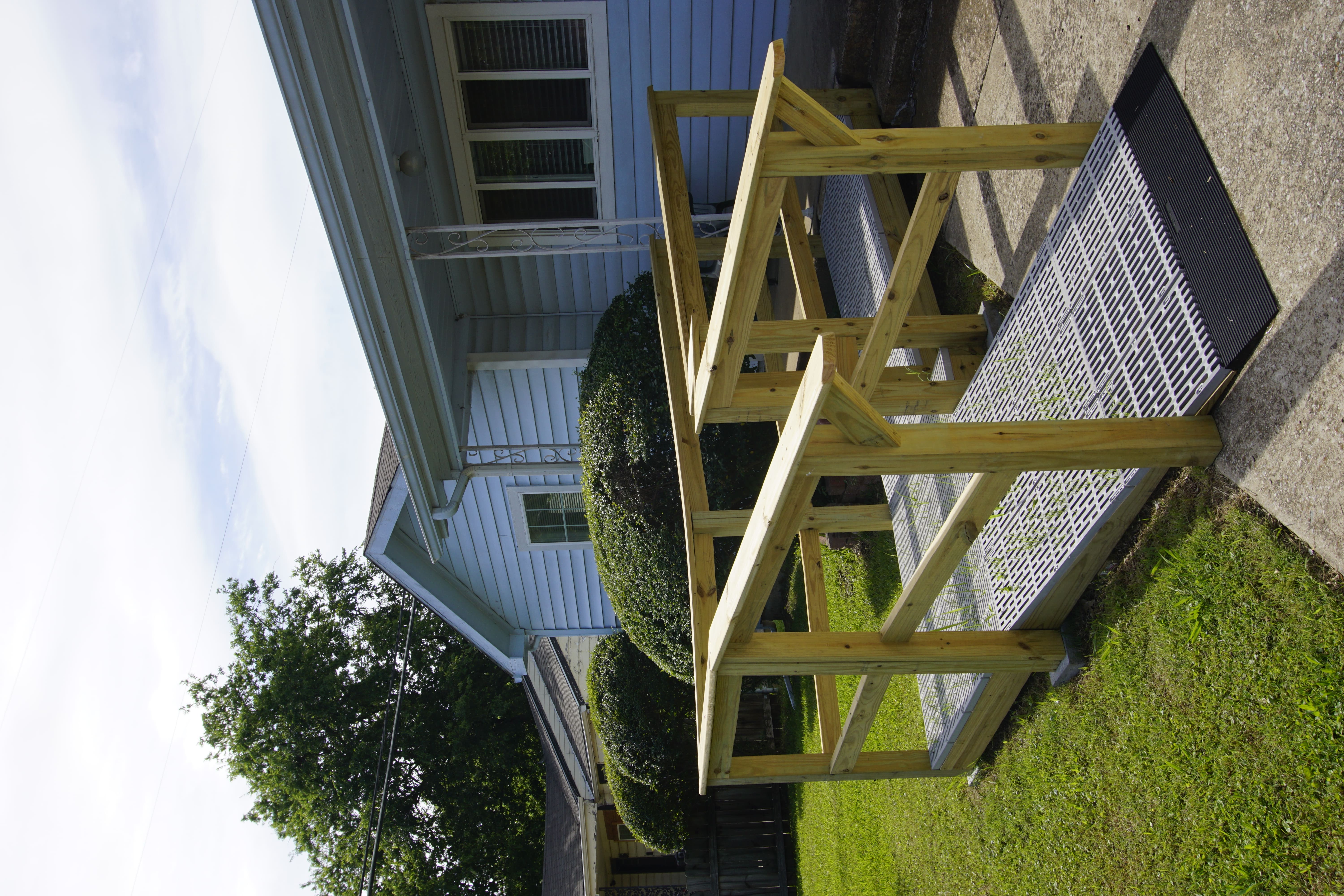 Wooden wheelchair ramp with handrails at a residential home entrance